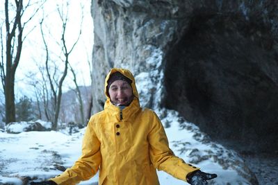 Portrait of mid adult woman standing by mountain during winter