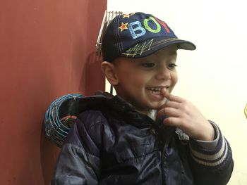 Portrait of smiling boy against wall