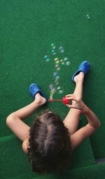 High angle view of child blowing bubles