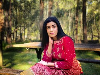 Portrait of young woman sitting in forest