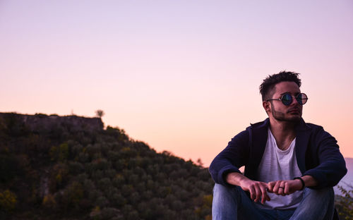 Portrait of man wearing sunglasses against sky during sunset