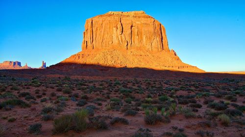 View of rock formations on landscape against blue sky