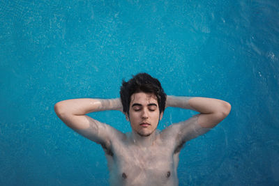Portrait of shirtless man swimming in pool
