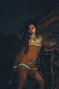 Portrait of young woman standing at junkyard