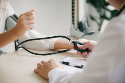 Midsection of doctor examining patient in hospital