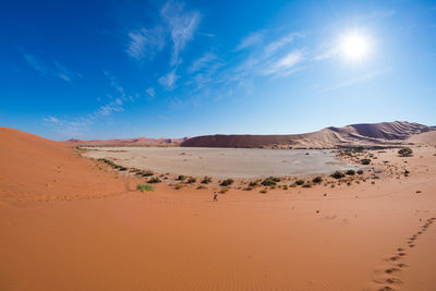 Scenic view of desert against blue sky