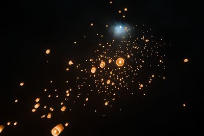 Low angle view of illuminated sky lanterns at night