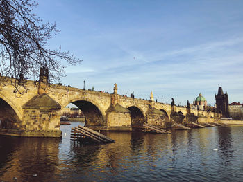 Arch bridge over river against sky