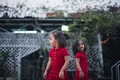 Twin sisters standing in backyard