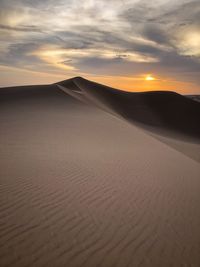 Scenic view of desert against sky during sunset