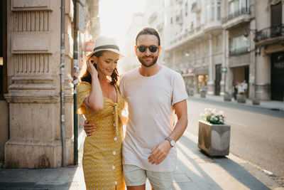 Portrait of smiling couple standing in city