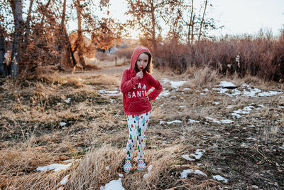 Young girl with hand on hip standing in a field