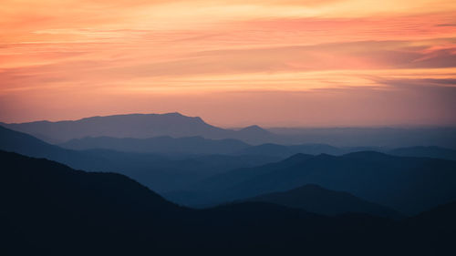 Scenic view of silhouette mountains against sky during sunset