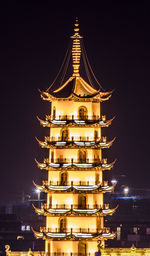 Illuminated building against sky at night