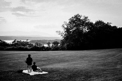 Rear view of people sitting on tree
