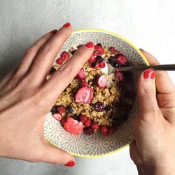 Cropped image of woman holding breakfast bowl on table