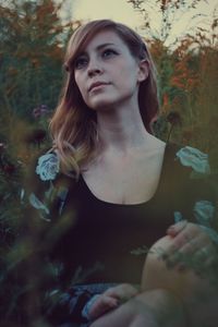 Young woman sitting in flower field