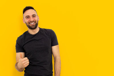 Portrait of a smiling young man against yellow background