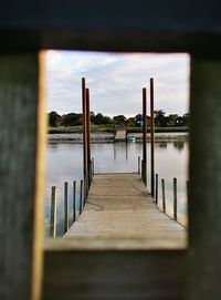 Pier on lake against sky