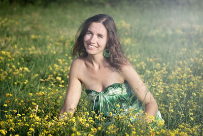 Portrait of young woman with flowers in field