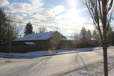 Houses by buildings against sky during winter