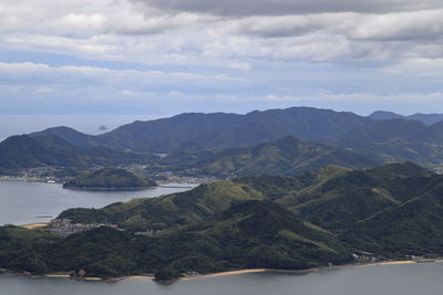 Scenic view of sea and mountains against sky