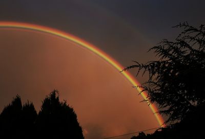 Low angle view of rainbow against sky at sunset