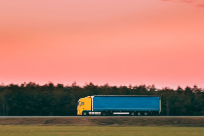 Car on road against sky at sunset