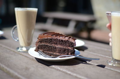 Close-up of chocolate cake with latte served on table at cafe