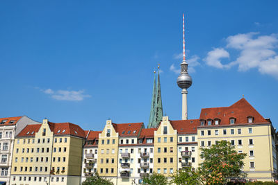 Buildings in city against blue sky