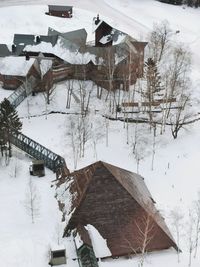 Houses on snow covered house by trees