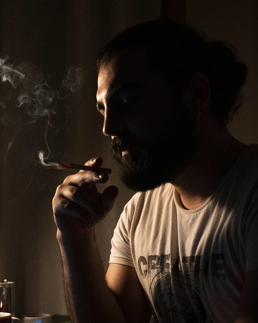 smoking, smoke, smoking issues, cigarette, one person, bad habit, tobacco products, adult, darkness, indoors, social issues, black, portrait, activity, young adult, headshot, men, lifestyles, holding, warning sign, risk, communication, person, sign, singing, waist up, light, facial hair, beard