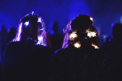 Rear view of women with illuminated decorations on hair