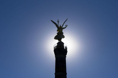 Low angle view of silhouette victory column against clear sky on sunny day