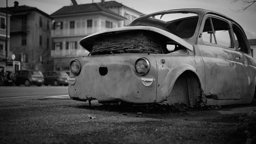 Abandoned car on street in city