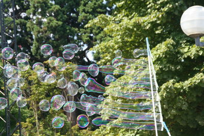 Low angle view of bubble wand against trees at park