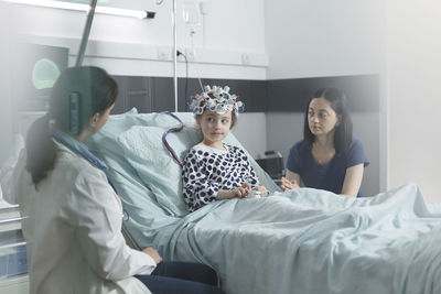 Doctor taking eeg reading of girl in hospital