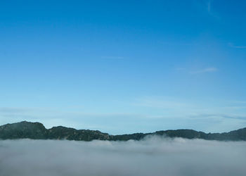 Scenic view of mountains against blue sky