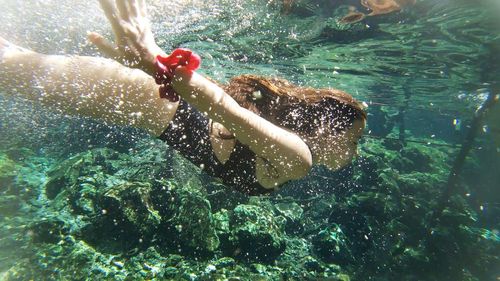 Low section of man swimming in sea