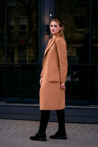 Portrait of young woman standing in city