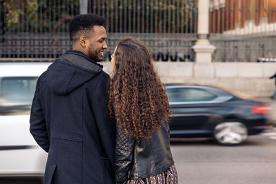 Woman standing by car in city