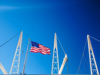 Low angle view of american flag at utah olympic oval against clear blue sky