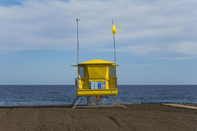 Lifeguard hut on beach against sky