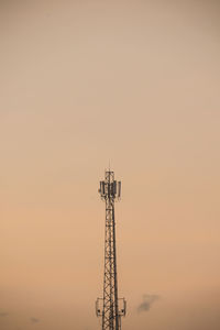 Low angle view of communications tower against sky during sunset