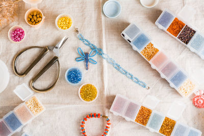 Items for beading - boxes with beads, thread and scissors on the table. 