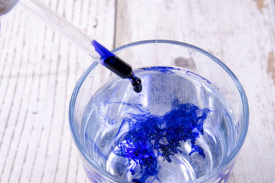 High angle view of blue glass with water on table