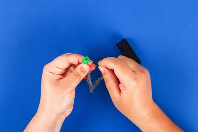 Close-up of woman hand against blue background