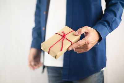 Midsection of man holding paper in box