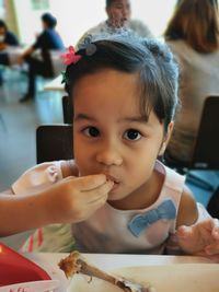 Portrait of cute girl eating at restaurant