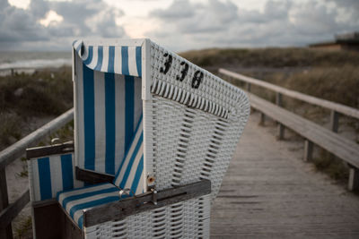 Close-up of beach chair on wooden post 